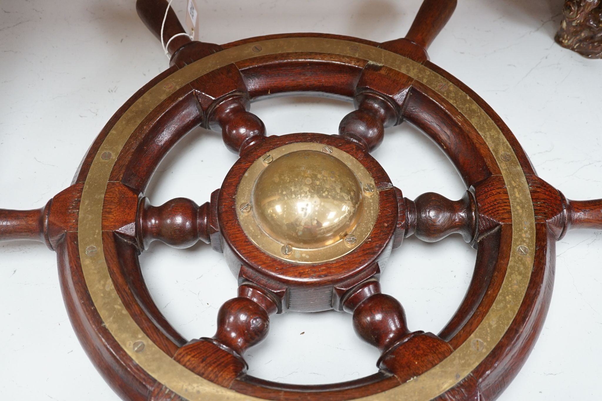 An early 20th century teak and brass mounted ship’s wheel 64cm